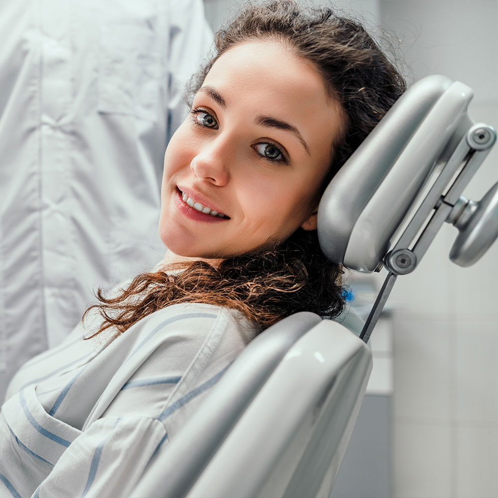 A dental professional is assisting a patient with a digital display of the patient s mouth, highlighting dental work in progress.